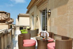 a patio with wicker chairs and tables on a balcony at Majestic Apartments Champs Elysées in Paris