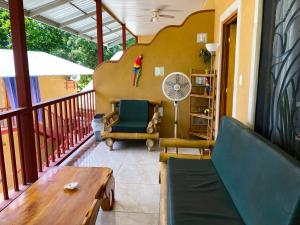 eine Veranda mit einem Sofa und einem Tisch auf dem Balkon in der Unterkunft Cabinas Jimenez in Puerto Jiménez