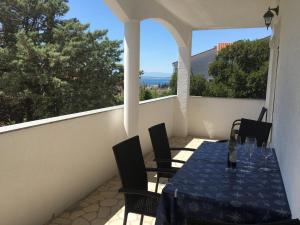 a table and chairs on a balcony with a view at Apartman Mirno More in Selce