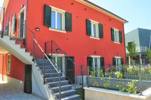 un edificio rojo con escaleras delante en Liguria Village en Brugnato