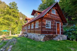 een klein houten huis op een groen gazon bij Chalupa 47 in Hřensko