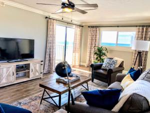 a living room with a couch and a tv at Regency Towers - beachfront condo in Panama City Beach