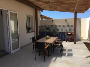 a patio with a wooden table and chairs at Casa Vigna da Michela in Favignana