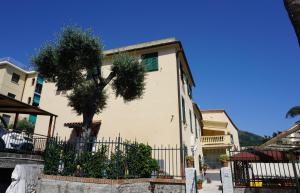 a building with a tree in front of a fence at Appartamento Villa Cristina in Genoa