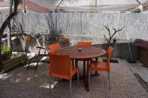 a wooden table with orange chairs on a patio at Appartamento Villa Cristina in Genoa