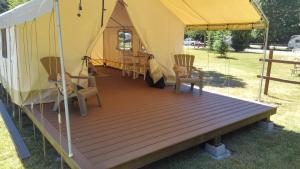 a yurt with chairs and a wooden deck at Redwood Meadows RV Resort in Crescent City