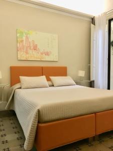 a bedroom with a large bed with an orange headboard at Sangiuliano114 B&B in Catania