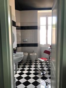 La salle de bains est pourvue d'un sol en damier noir et blanc. dans l'établissement Sparkling Art Como, à Côme