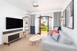 a living room with a couch and a tv at HD Parque Cristobal Tenerife in Playa de las Americas