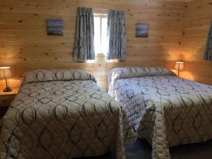 a bedroom with two beds in a log cabin at Cavendish Maples Cottages in Cavendish