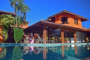 uma casa com uma piscina em frente em Pousada Mais Bella em Ilhabela