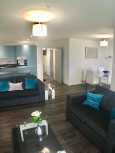 a living room with two couches and a table at Impressive newly built apartment in Conwy