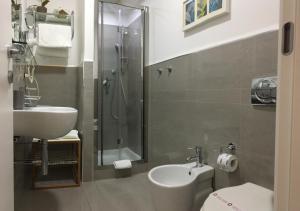y baño con ducha, aseo y lavamanos. en Sangiuliano114 B&B, en Catania