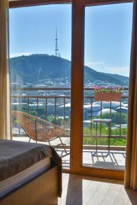 Habitación con cama y balcón con vistas. en Hotel Livin en Tiflis