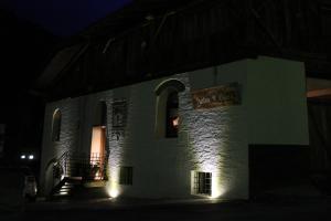 a building with a sign on the side of it at night at Locanda dei gentili in Ossana
