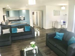 a living room with two couches and a kitchen at Impressive newly built apartment in Conwy