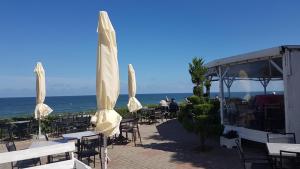 a group of tables and chairs with umbrellas on the beach at SAILOR Ustronie Morskie in Ustronie Morskie