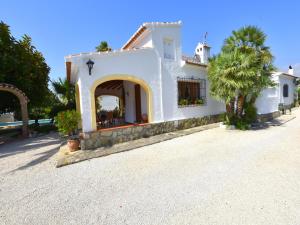 a white house with a palm tree in the driveway at Casa Juanita in Jávea