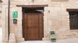a building with a wooden door with a sign on it at Castillo de Portilla Casa Rural in Portilla