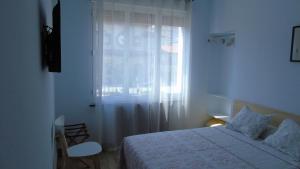 a white bedroom with a bed and a window at PENSION OVIEDO in Oviedo +3 photos
