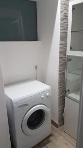een wasmachine en droger in een kamer met een badkamer bij Casa Gialli in Catania