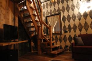 a wooden staircase in a living room with a television at Locanda dei gentili in Ossana