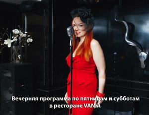 a woman in a red dress singing into a microphone at Vania Rooms Hotel in Vladimir