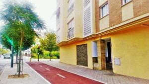 ein Gebäude auf der Seite einer Straße mit einem roten Bürgersteig in der Unterkunft Martin House & Granada in Granada