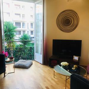 Una televisión o centro de entretenimiento en Nice Apartment Roses & Ivy, Rue du Congres