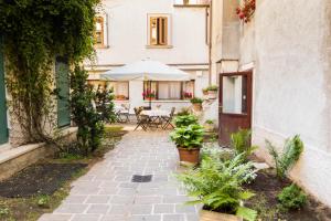 un patio al aire libre con mesa y sombrilla en Hotel Alle Vecchie Arcate, en Pescasseroli