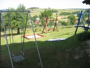 um baloiço num quintal com um parque infantil em Gospodarstwo Agroturystyczne Handzlówka em Skawa