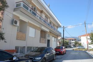two cars parked in front of a building at Daisy Apartment in Asprovalta