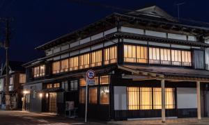 um edifício preto e branco com janelas à noite em GUEST HOUSE Googoo em Niigata