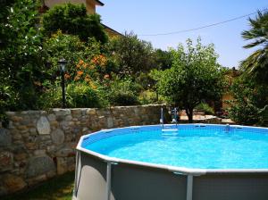 a hot tub in a yard with a stone wall at Parte di casa con giardino e piscina in Pietrasanta