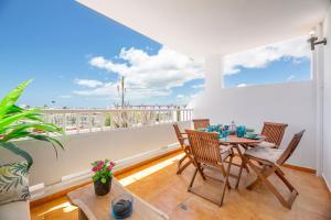 a dining room with a table and chairs on a balcony at The Colors House, 653 y 654 - Private Apartment in Costa Teguise