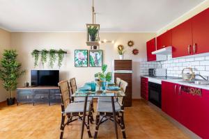 a kitchen with red cabinets and a table with chairs at The Colors House, 653 y 654 - Private Apartment in Costa Teguise