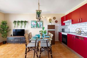 コスタ・テギセにあるThe Colors House, 653 y 654 - Private Apartmentのキッチン(赤いキャビネット、テーブル、椅子付)