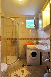 a bathroom with a shower sink and a washing machine at Apartments Banicevic in Tivat