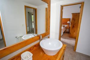 baño con lavabo y espejo grande en Cabañas Villa Sequoia en San Carlos de Bariloche