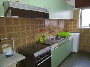 a kitchen with a sink and a stove at quartos da praia in Peniche