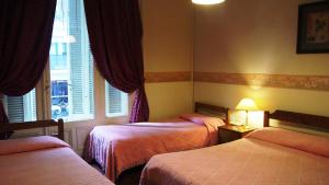 a hotel room with two beds and a window at Hotel Gran Sarmiento in Buenos Aires