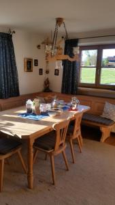 una mesa de madera con sillas en la sala de estar. en Woidhauserhof en Waakirchen