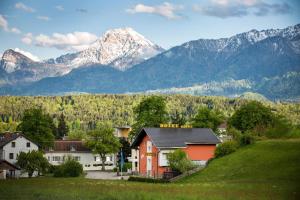 a house on a hill with mountains in the background at Hotel Garni Sohler in Villach