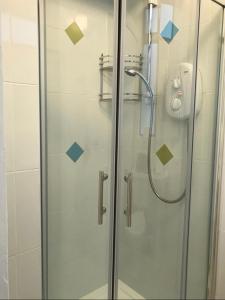 y baño con ducha y puerta de cristal. en Crescent Close en Galway