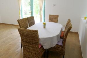 uma mesa de jantar com cadeiras de vime e uma toalha de mesa branca em Pensiunea HAPPY em Schitu-Topolniţei