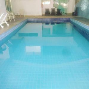 a large swimming pool with blue tiles on the floor at RECANTO MARIANE in Santo Antônio do Amparo