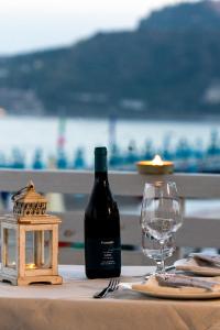 a bottle of wine sitting on a table with a glass at Taormina Beach House in Mazzeo