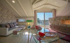 een woonkamer met een bank en een tafel bij Villa Daizy Boutique Apartments in Laganas