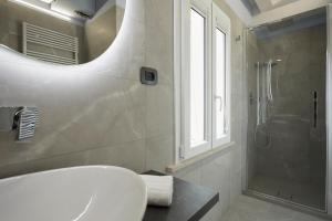 uma casa de banho com um lavatório branco e um chuveiro em Affittacamere Somnium em Sirolo