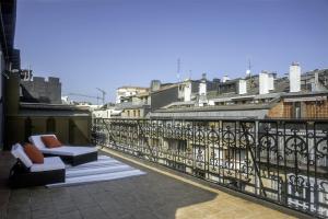 a balcony with a couch and chairs on a roof at Always Easy I Suite Terraza in San Sebastián